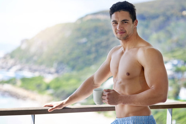 Awesome coffee, awesome view. a handsome young man having coffee out on the balcony in the morning - Фото, зображення
