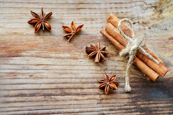 Cinnamon sticks and spicy anise stars on wooden table - Fotó, kép