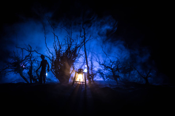 Karanlık ormanda duran bir insan silueti. Korku Cadılar Bayramı konsepti. Gecenin karanlığında ürkütücü bir ormanda tuhaf bir siluet. - Fotoğraf, Görsel