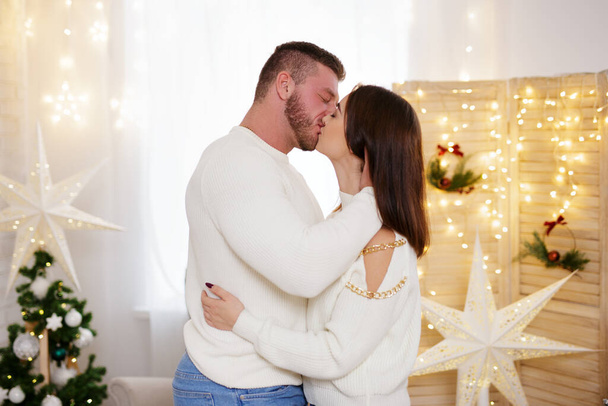 Piękna para całuje się w pokoju urządzone Boże Narodzenie - Zdjęcie, obraz