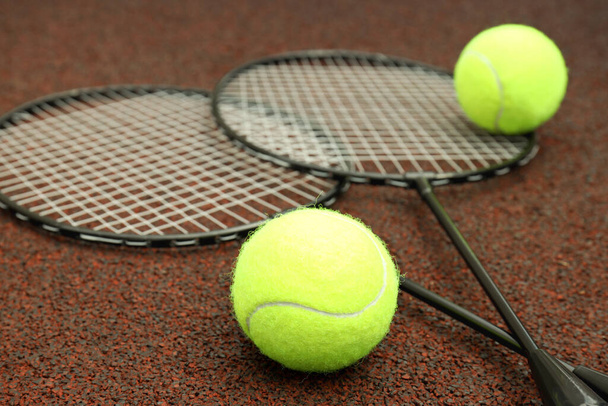 Badminton rackets and tennis balls on playground rubber coating - Zdjęcie, obraz
