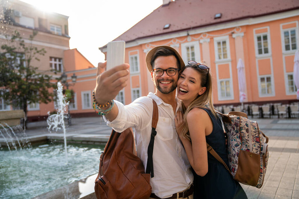 Happy traveling young couple taking selfie, having fun on vacation. People technology happiness concept. - Foto, Imagem