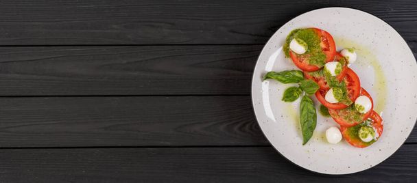 Salada caprese tradicional italiana com tomate fatiado, mussarela, manjericão e azeite em um fundo de madeira. Vista superior, lugar para texto. Banner - Foto, Imagem