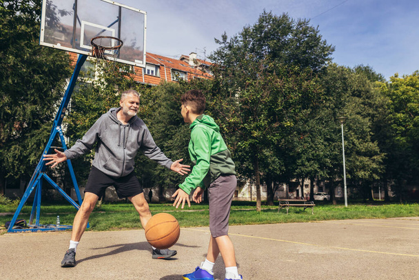 Hombre maduro jugando baloncesto con su hijo - Foto, imagen