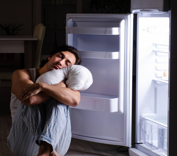 Человек, нарушающий диету ночью возле холодильника - Фото, изображение