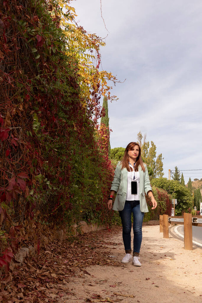 Kahverengi saçlı kız sonbahar manzaralarında yürüyor. - Fotoğraf, Görsel