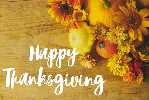 Feliz cartão de felicitações de Acção de Graças. O texto feliz do Thanksgiving no apartamento do outono coloca com flores, abóboras, abóboras na mesa de madeira. Letras manuscritas - Foto, Imagem