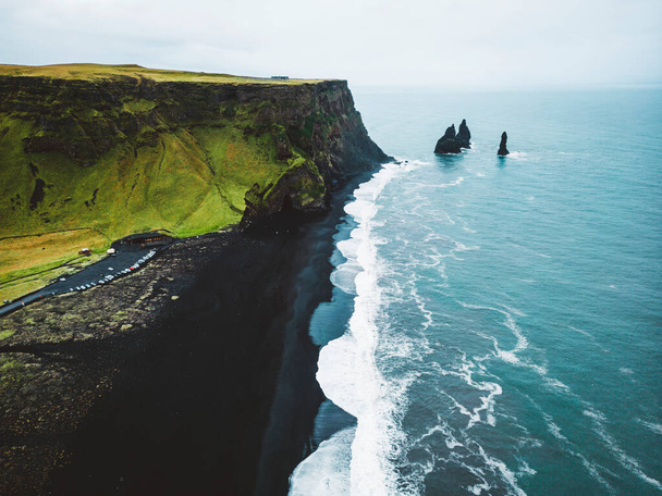 Praia de Areia Negra Vulcânica com vista para Reynisdrangar. Ondas a cair na praia de areia negra. Vik, Islândia. Foto de alta qualidade - Foto, Imagem