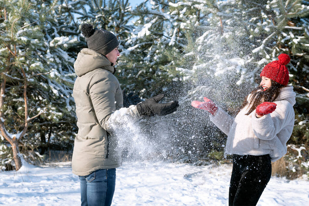Guy i dziewczyna są przyjaciółmi w mroźny słoneczny dzień grając w śnieżki. Zimowe związki wakacyjne - Zdjęcie, obraz