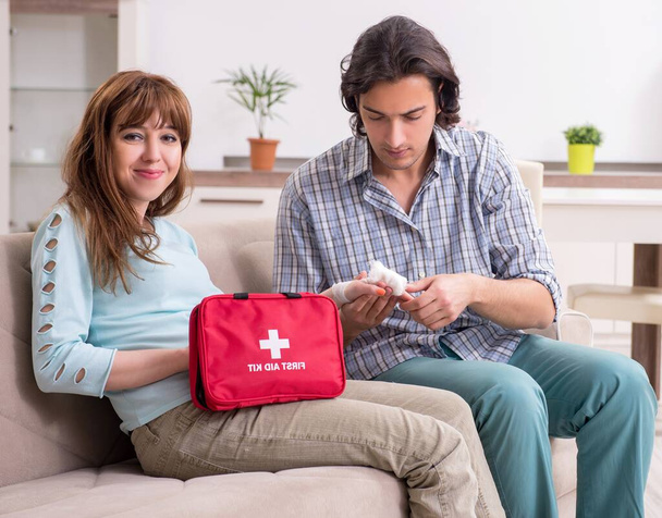 The young couple in first aid concept at home - Photo, Image