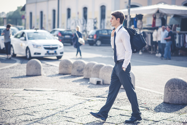 Hombre rubio con bolsa caminando por la calle
 - Foto, imagen