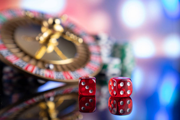 Θέμα καζίνο. Τυχερά παιχνίδια. Ρουλέτα, ζάρια, κάρτες και μάρκες πόκερ σε ένα πολύχρωμο φόντο bokeh. - Φωτογραφία, εικόνα