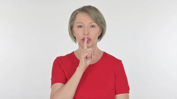 Ησυχία παρακαλώ, ηλικιωμένη γυναίκα με δάχτυλο στα χείλη σε λευκό φόντο - Φωτογραφία, εικόνα