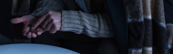 περικοπή άποψη του ανθρώπου σε ζεστή κουβέρτα καταμέτρηση των κερμάτων κατά τη διάρκεια συσκότισης ενέργειας, πανό - Φωτογραφία, εικόνα