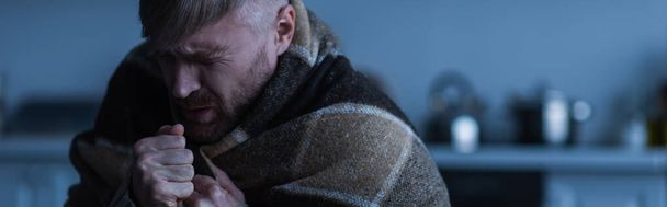 stressed man wrapped in warm blanket sitting in twilight with closed eyes, banner - Φωτογραφία, εικόνα