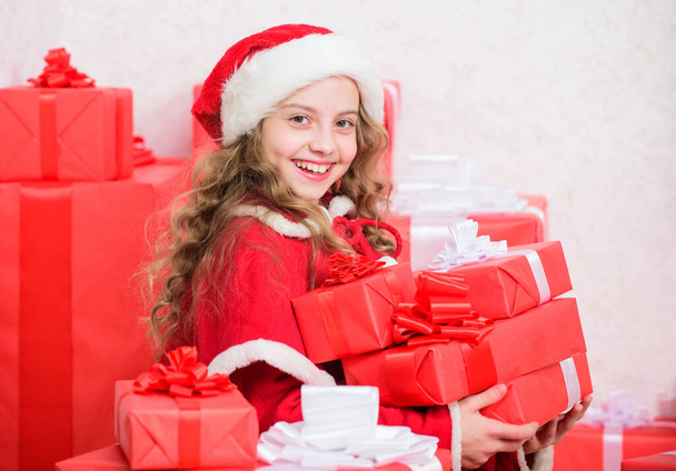 Explore christmas gifts. Unpacking christmas gift. Kid excited about opening christmas present. Girl celebrate christmas. Kid helping santa. New year holiday tradition. Little santas helper concept. - Фото, изображение