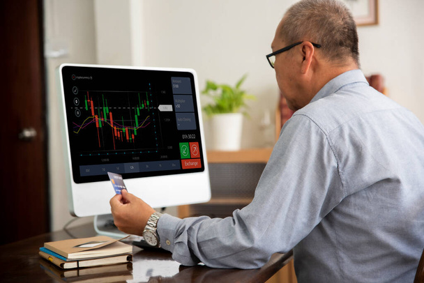Senior asiático hombre usando computadora comercio bolsa de valores en línea en casa. - Foto, Imagen