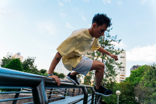 Cool and confident boy practicing parkour tricks in the city and having fun. - Foto, immagini