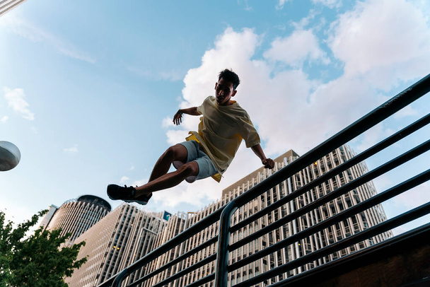 Cool and confident boy practicing parkour tricks in the city and having fun. - Foto, afbeelding