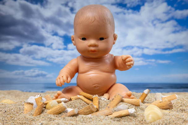 Дитяча лялька в оточенні сигарет на красивому пляжі
  - Фото, зображення