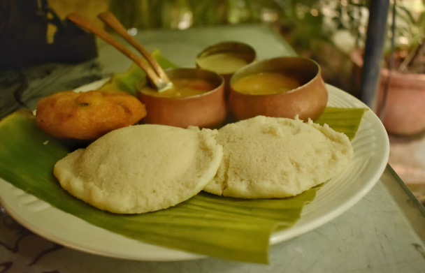 Een close-up van Idly, vada en sambar op een restaurant tafel in India tijdens de dag. Het is een South Indian Breakfast delicatesse - Foto, afbeelding