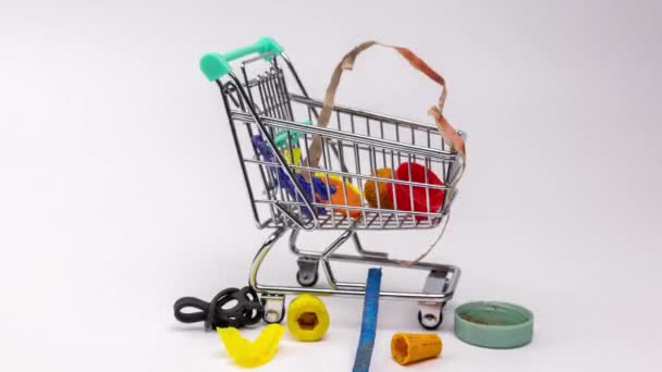 A műanyag szemét és hulladékok makró stop mozgása egy bevásárlókocsiban - Felvétel, videó