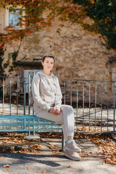 Aantrekkelijke jonge vrouw zittend op een bankje genietend van een uitzicht op de middeleeuwse stad in Europa. Begrip zomervakantie. - Foto, afbeelding