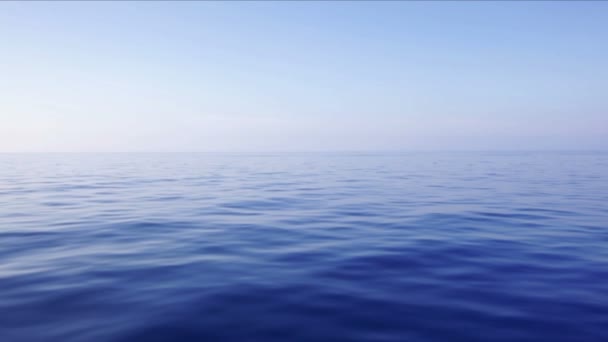 Vista grandangolare al rallentatore di dolci onde ondulate e di un cielo azzurro chiaro, scattato da una barca sull'Oceano Atlantico - Filmati, video