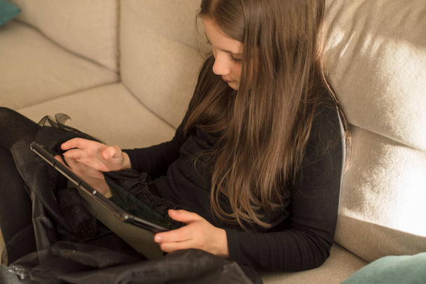 Schülerin spielt auf dem Tablet. Soziale Netzwerke, Spiele und Kinderkonzept - Foto, Bild