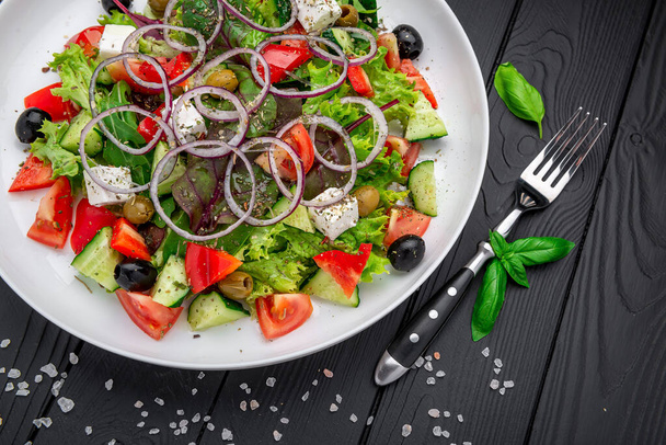 Görög saláta olívaolajjal, friss zöldségekkel, olajbogyóval és fetta sajttal. Egészséges élelmiszer. - Fotó, kép