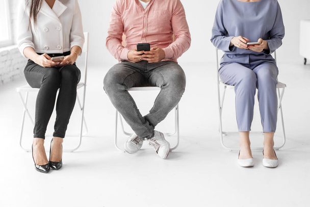 group of people sitting on chairs and using digital devices, concept, original photoset  - Foto, Imagen