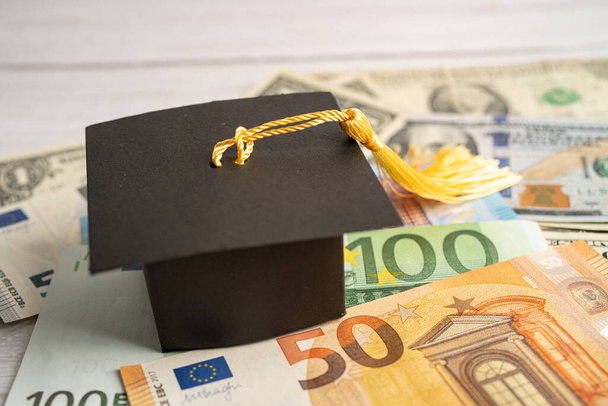 Graduation gap hat on US dollar banknotes money, Education study fee learning teach concept. - Zdjęcie, obraz