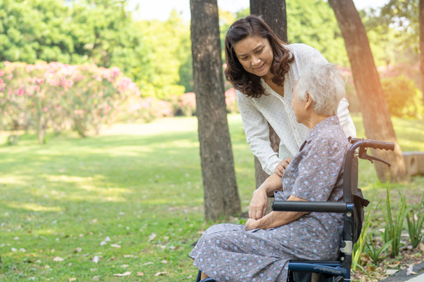 Assistenza e assistenza Anziani asiatici o anziani paziente donna anziana seduta e felice sulla sedia a rotelle nel parco, sano forte concetto medico. - Foto, immagini