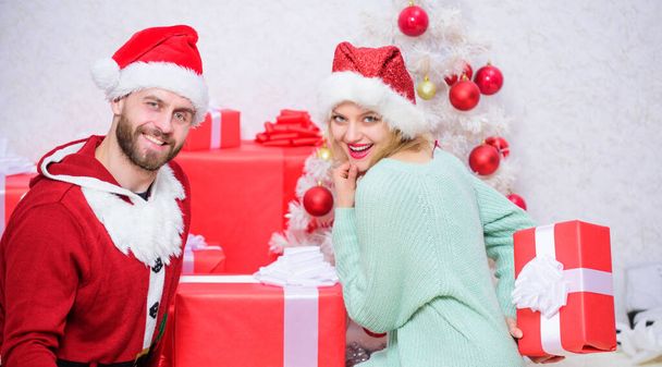 Opening christmas present. Family prepared christmas surprise. Couple in love happy enjoy christmas holiday celebration. Loving couple cuddle smiling while unpacking gift christmas tree background. - 写真・画像
