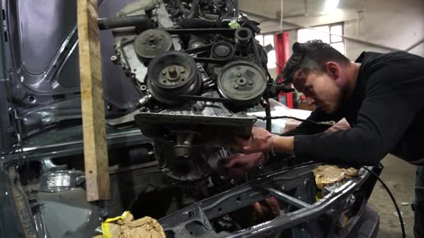 réparation de moteur enlever d'une vieille voiture grise pour le réglage - Séquence, vidéo