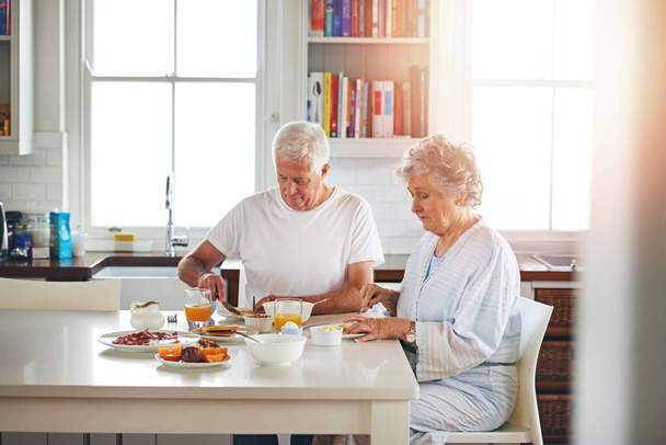 Versteckt in einem gemütlichen Frühstück. ein älteres Ehepaar frühstückt gemeinsam zu Hause - Foto, Bild