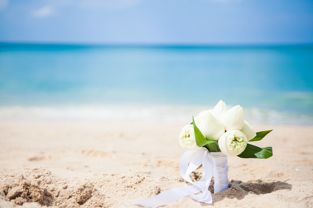 Wedding bouquet lotus on the background of the sea on the beach on old three grass - Foto, Imagen