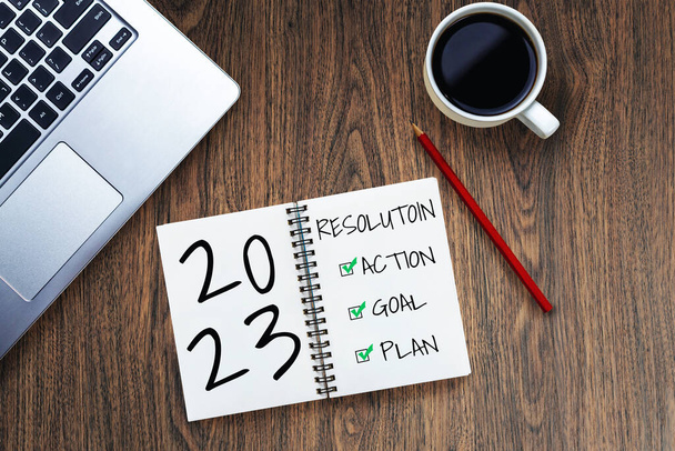 2023 Lista de objetivos y establecimiento de planes de feliz año nuevo - Escritorio de oficina de negocios con cuaderno escrito sobre la lista de planes de metas de año nuevo y el establecimiento de resoluciones. Cambio y concepto de determinación. - Foto, imagen
