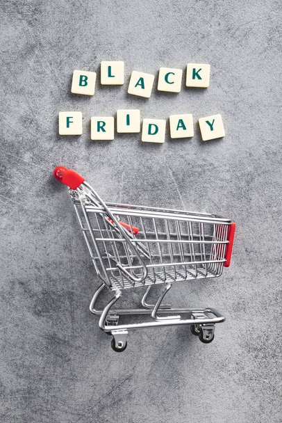 Black friday text and shopping cart on the gray background. Top view. - Fotó, kép