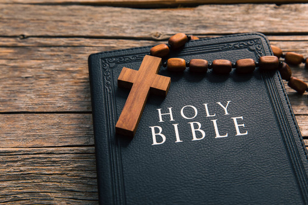 wooden cross with Holy Bible on tabl - Фото, зображення