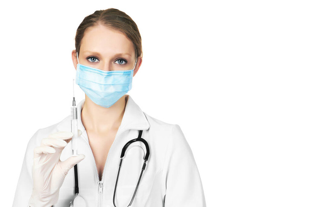 Medico donna in maschera con stetoscopio e siringa, isolato su sfondo bianco - Foto, immagini