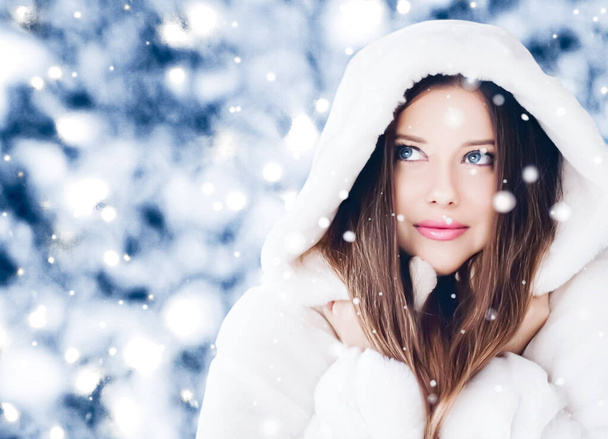Felices fiestas, estilo de vida y moda de invierno, hermosa mujer con abrigo de piel esponjosa blanca, nevando nieve en la naturaleza del bosque nevado como Navidad, Año Nuevo y estilo de retrato de vacaciones - Foto, Imagen
