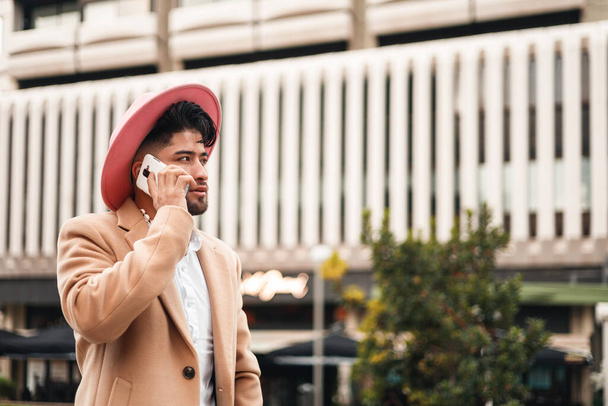 joven colombiano elegante hombre usando teléfono inteligente, tiro vertical - Foto, imagen