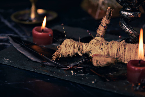 Voodoo lalka w rytualnej scenie zbliżenie, magiczny stół ze świecami, czary i koncepcja duchowości - Zdjęcie, obraz