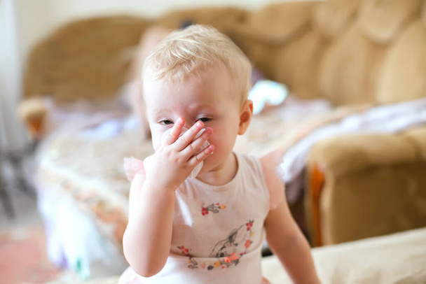 Dítě si vytahuje nos nosem, když mu teče z nosu. Nemocné dítě se naučí dostat ven. Krásná dívka s nachlazenou a virovou rýmou. - Fotografie, Obrázek