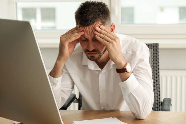 Sleep deprived man at workplace in office - Photo, image