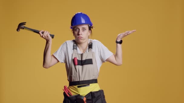 Portrait of confused handywoman raising shoulders and doing i dont know gesture, acting clueless and puzzled. Uncertain female constructor having no idea about answer, unknown doubt. - Footage, Video