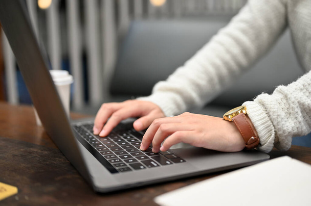 Κλείσιμο προβολής της γυναικείας δακτυλογράφησης σε φορητό υπολογιστή, ενώ εργάζονται σε ένα καφέ. έννοια της απομακρυσμένης εργασίας - Φωτογραφία, εικόνα