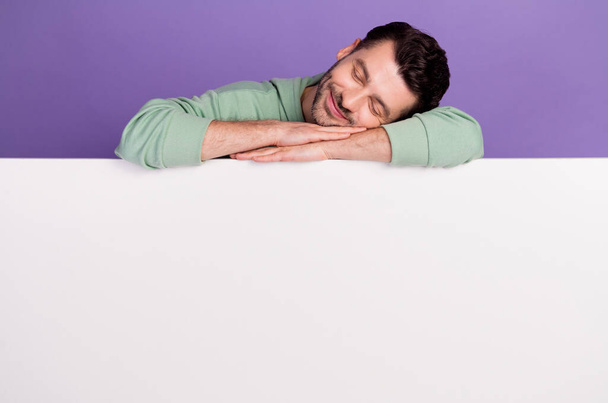 Photo portrait of attractive young man leaning sleeping white poster space wear trendy gray outfit isolated on violet color background. - Fotó, kép