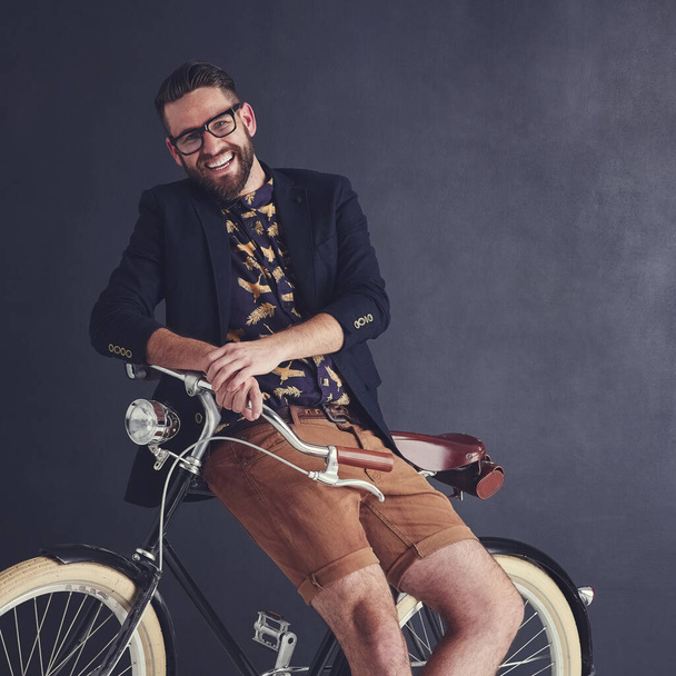 My style rules. Portrait of a trendy young man posing in studio with his bicycle - Foto, Bild